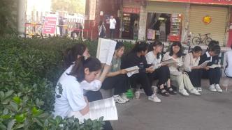 考生們坐路旁復習等開考：臨陣磨槍，不快也光