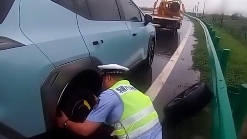 暴雨中交警为车主换轮胎