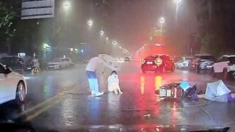 女孩遇事故淋雨坐路中，过路司机停车送伞并报警