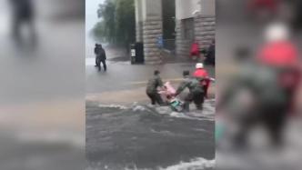 暴雨中，兵哥哥奔跑着帮助被困积水的路人