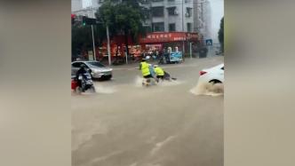 暴雨中交警奔跑着帮助被困积水中的路人
