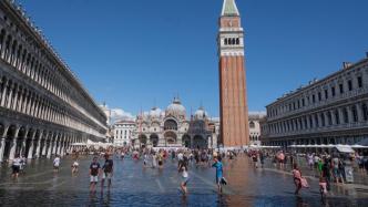 威尼斯水位上涨，游客在积水中观光，城市面临破坏风险