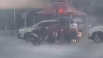 老伯骑摩托车摔倒，众志愿者暴雨天撑伞施救