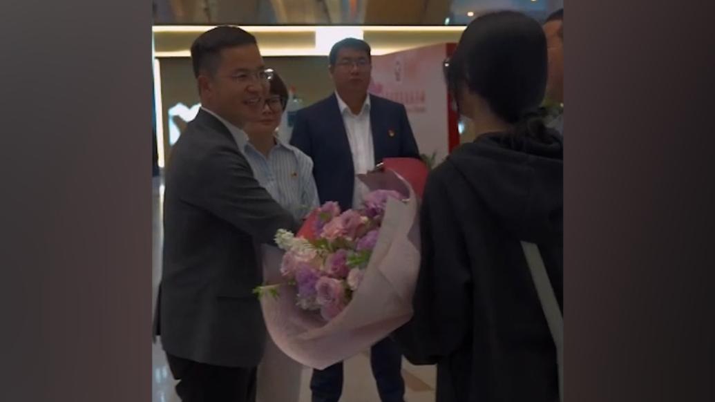 云南一高校校长在机场迎新生，送上鲜花和鲜花饼