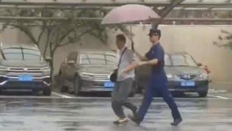 突降大雨，消防员撑伞带路人进队避雨