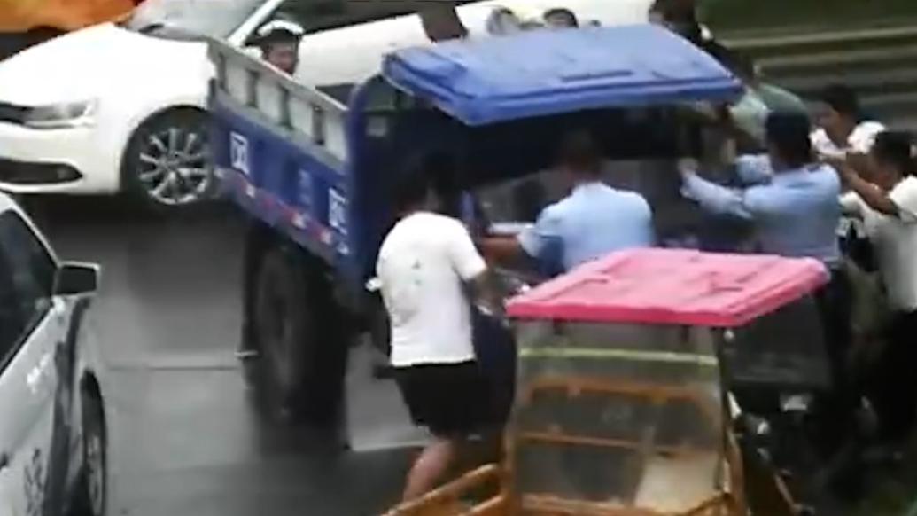 雨天三轮车在路边侧翻，众人纷纷搭手扶起