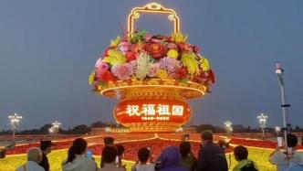 天安门广场巨型花篮亮灯，众多游客前来合影