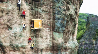 湖南一景区在悬崖壁上建便利店：为攀岩者设立，人工背水