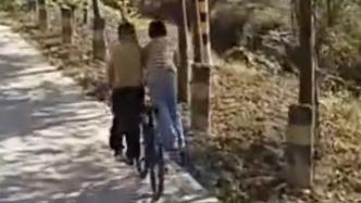 俩男孩同骑一辆自行车超默契