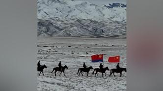 新疆戍边民警高举国旗在冰雪中策马巡边