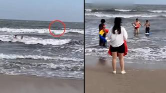 瞥见远方一名男孩在海里上下扑腾，同是母亲的她喊人救援