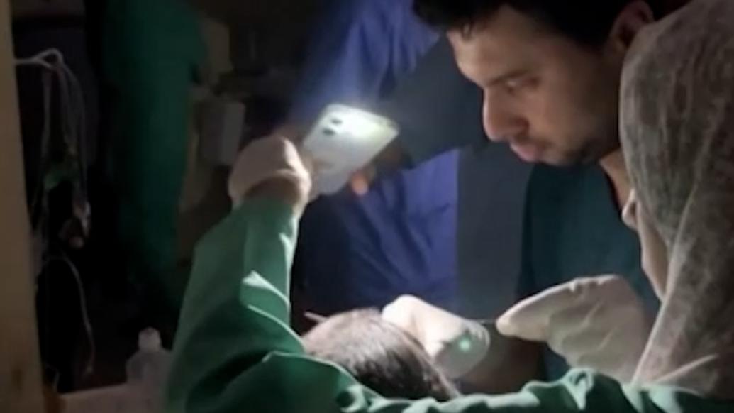 加沙地带断水停电，医生用手机照明做手术