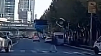惊险！上海一车辆转弯撞落红绿灯，险些砸中行人