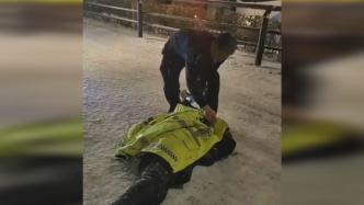 民警在风雪中脱下外衣为摔倒受伤的路人保暖