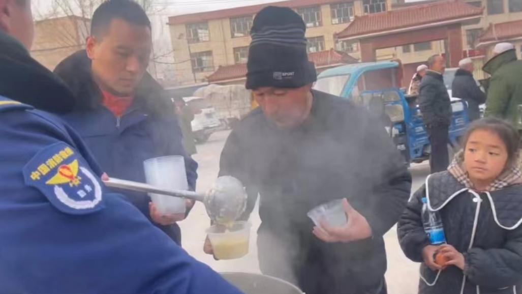 消防队员为灾区群众免费熬煮热小米粥，确保灾民吃得饱