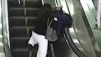 老人乘电梯不慎摔倒，身后女子用七步护住老人