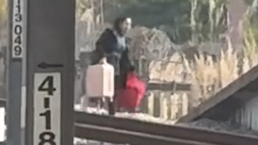 女子不顾工作人员喊话提着行李穿越铁轨，铁路警方介入