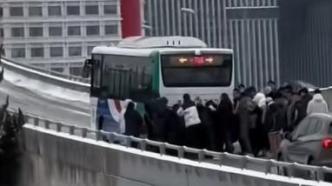公交雪地上桥打滑，爱心乘客集体推车