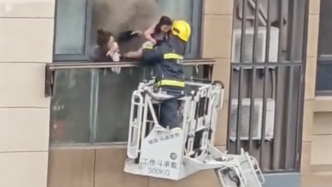 宁波一小区高层起火，消防员脚踩云梯、徒手砸晾衣架救人