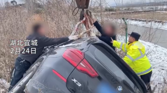 湖北宜城一小车因路面结冰滑进深沟，民警联系吊车施救成功