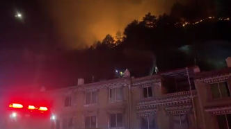 雅江县一酒店附近居民房面临两条火线威胁，消防救援人员堵截火势