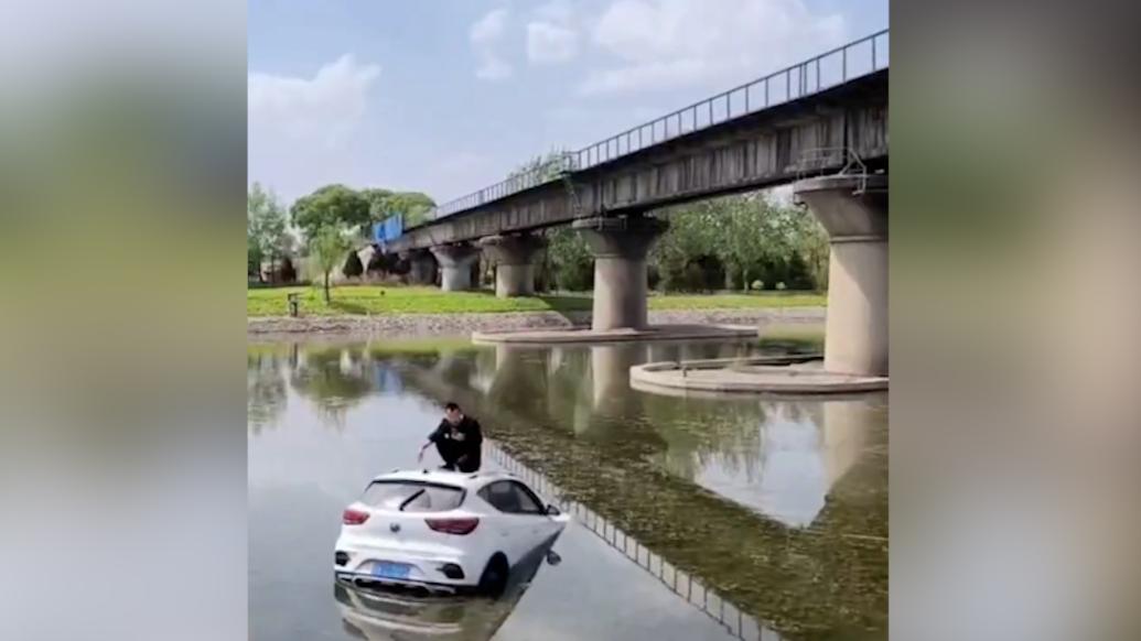 男子駕車墜河淡定蹲車頂刷手機(jī)