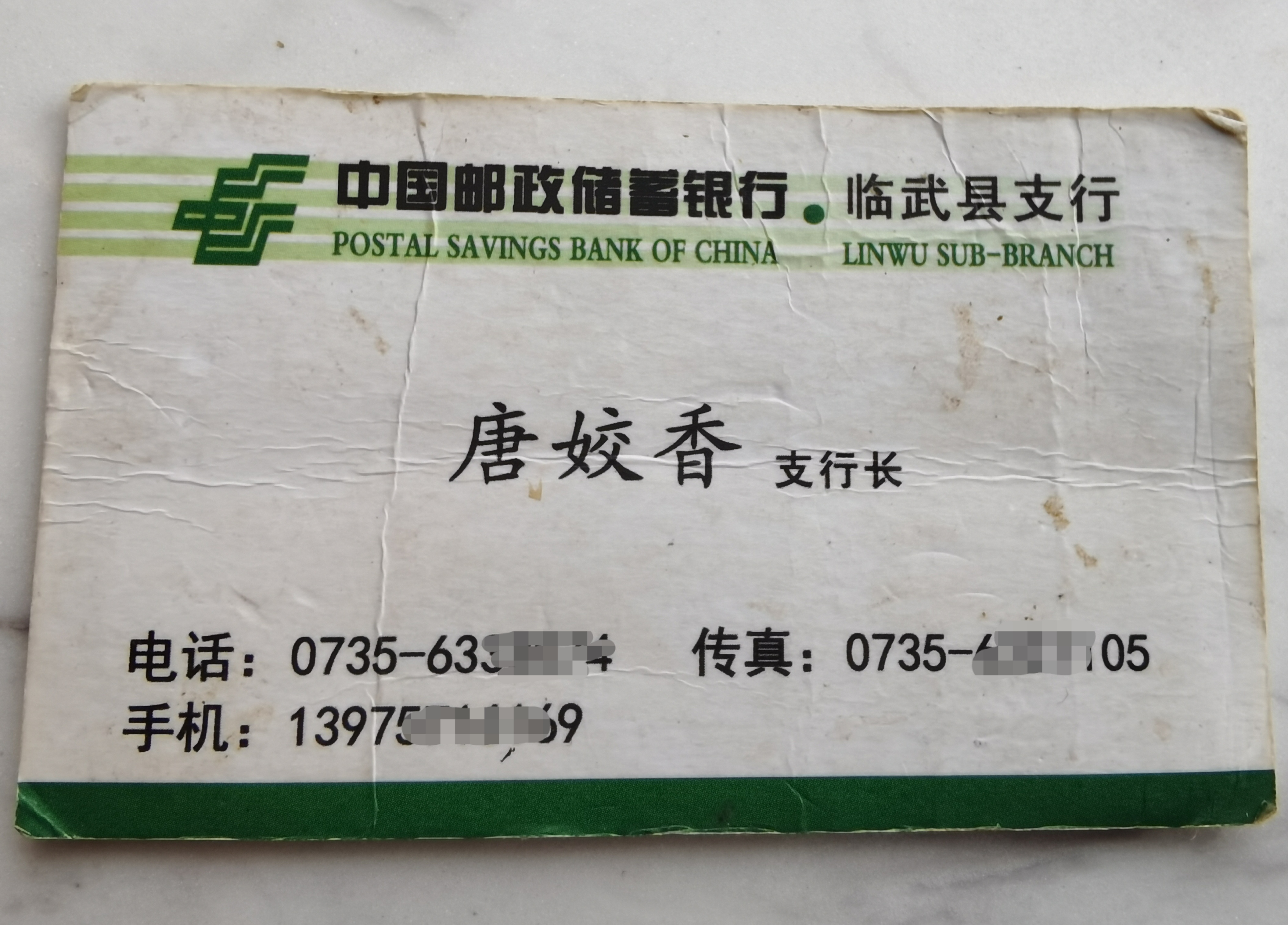 这张名片已有些发皱泛黄,上面显示,唐姣香的职务为邮储银行临武县支行