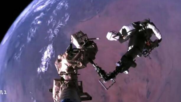中国航天员站在机械臂上与地球同框