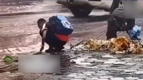 母亲言传身教，雨中带孩子清理下水道垃圾