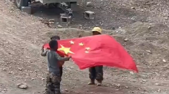 西藏小朋友手拿国旗模仿升旗手