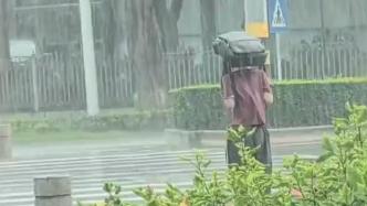 学生头顶书包冒雨过斑马线，一把雨伞突然出现……