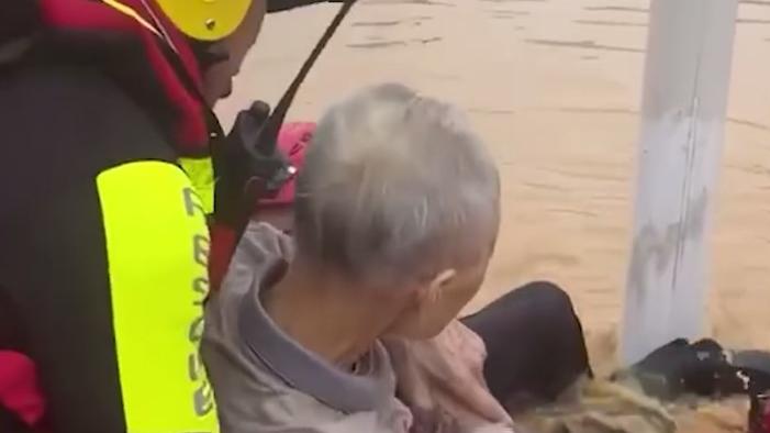 梅州一老人洪水中紧抱路灯被消防员救出