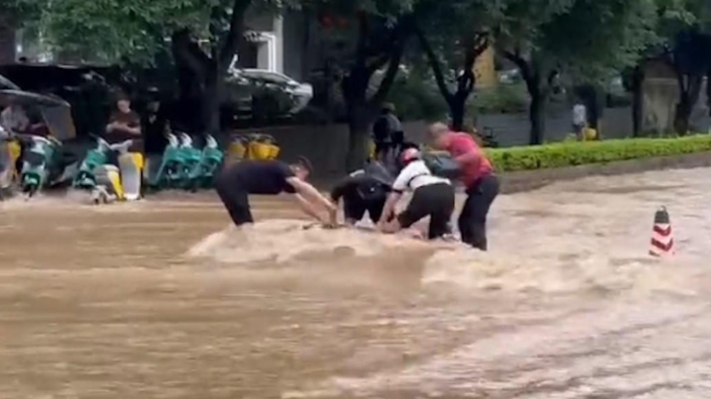 广西桂林：女子涉水过马路被冲倒，多名市民跳进水中扶起