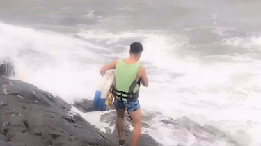 男子在海邊被浪卷走,附近店主帶上游泳圈沖入浪潮救人