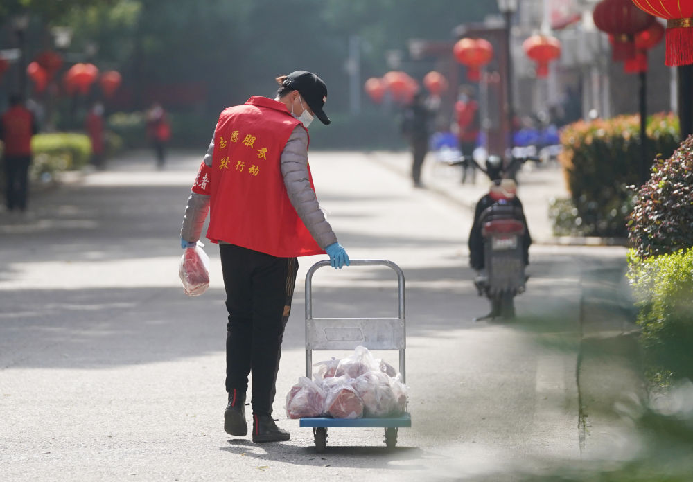 武汉东湖新城社区志愿者给居民运送生活物资(3月10日摄).