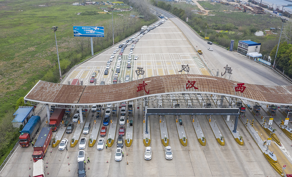 3月24日，在武汉西高速收费站交通卡点，返汉车辆排队等候入城（无人机照片）。