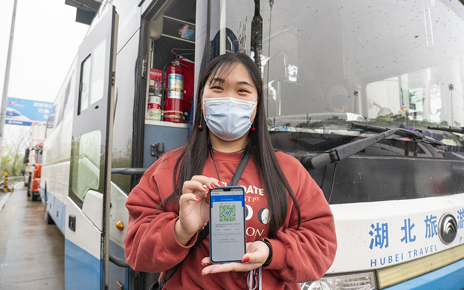 3月24日，在武汉西高速收费站交通卡点，一名返回武汉的东风本田员工展示自己的“绿码”。
