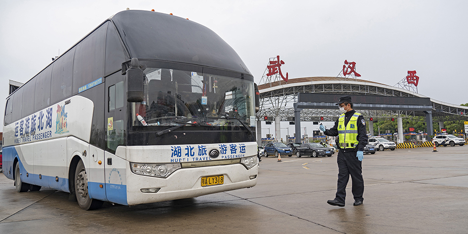 3月24日，在武汉西高速收费站交通卡点，执勤民警准备检查车辆。