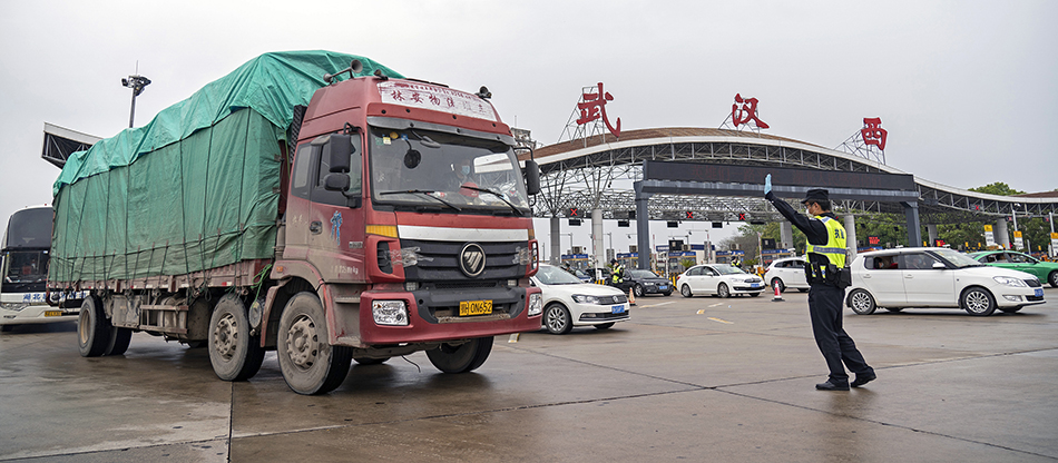 3月24日，在武汉西高速收费站交通卡点，执勤民警准备检查车辆。-2