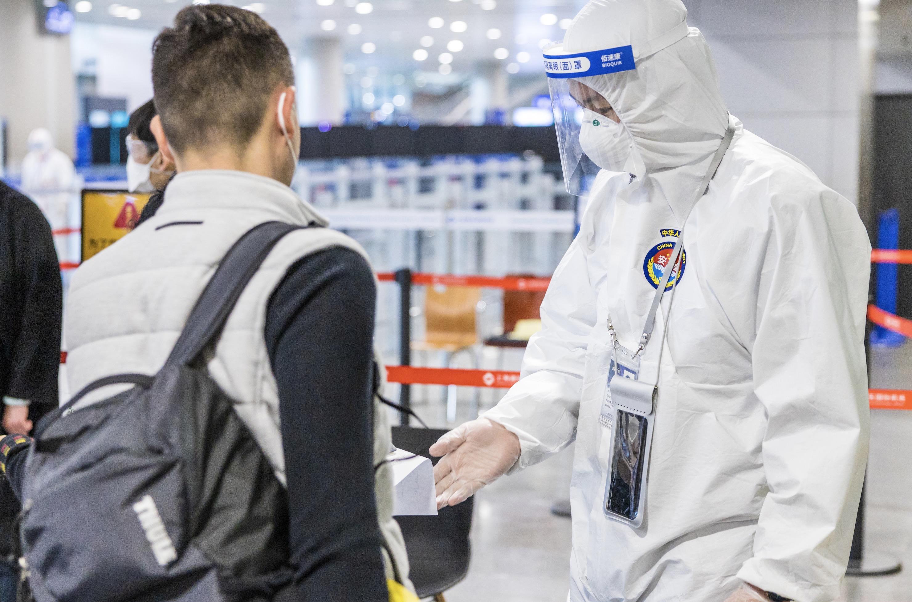 浦东机场安检员对入境旅客进行防控识别,分类引导