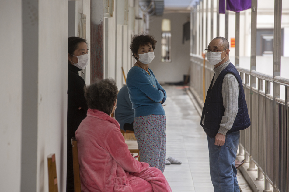3月25日，武汉软件职业学院康复隔离点，康复患者在走道闲聊。