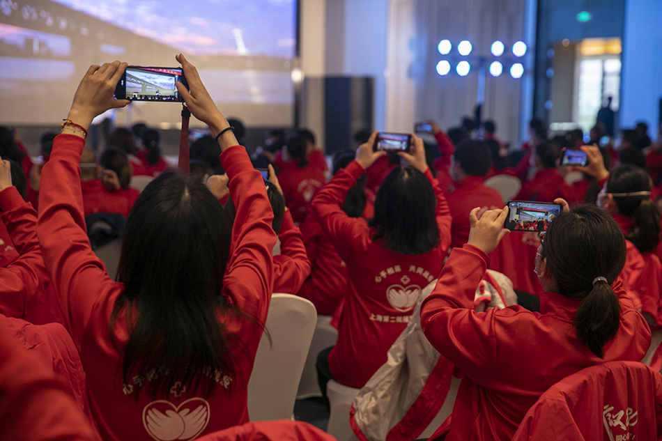 3月30日，武汉市东西湖区卓尔万豪，上海首批援汉医疗队的队员们在拍摄大屏幕上他们在金银潭工作的画面。