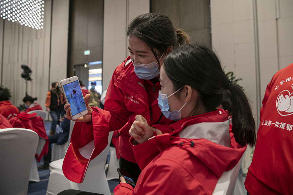 3月30日，武汉市东西湖区卓尔万豪，上海首批援汉医疗队的队员们在欢送仪式前观看他们在金银潭工作的视频。