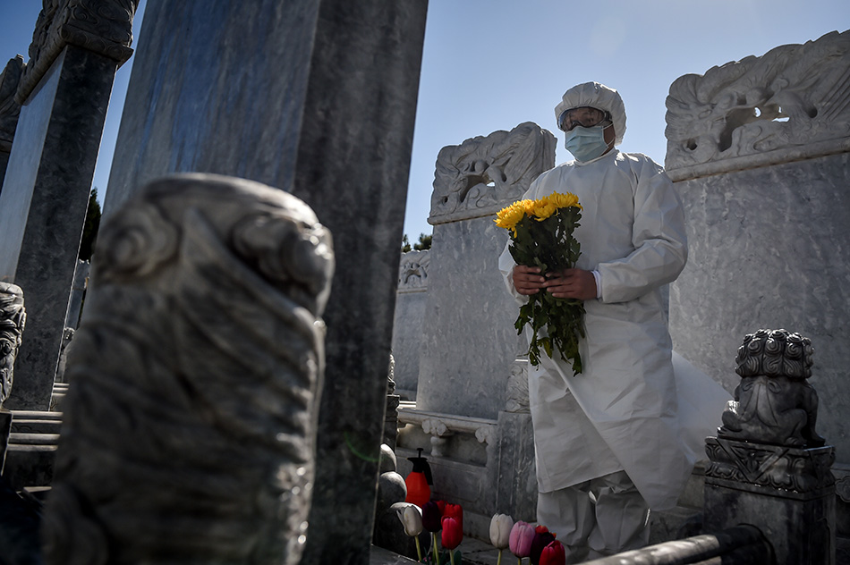 3月28日，北京八宝山人民公墓工作人员向墓碑献花。