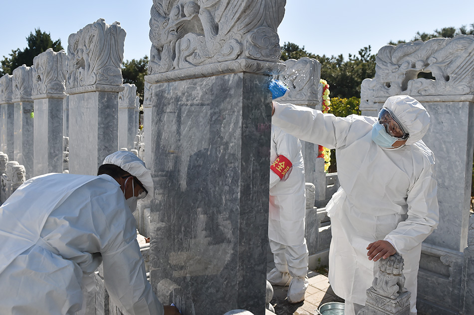 3月28日，北京八宝山人民公墓工作人员在擦洗墓碑。