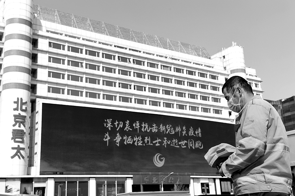 4月4日，在北京市西单街头，一位环卫工人脱帽默哀。
