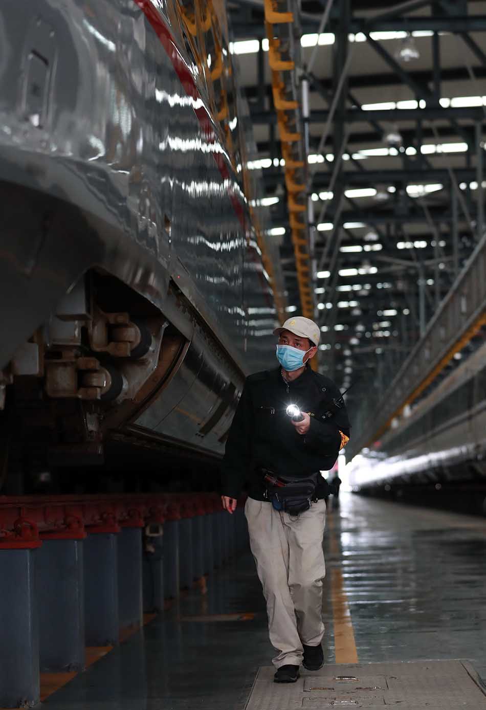 4月6日，武汉动车段一名维修人员检查高铁动车组。