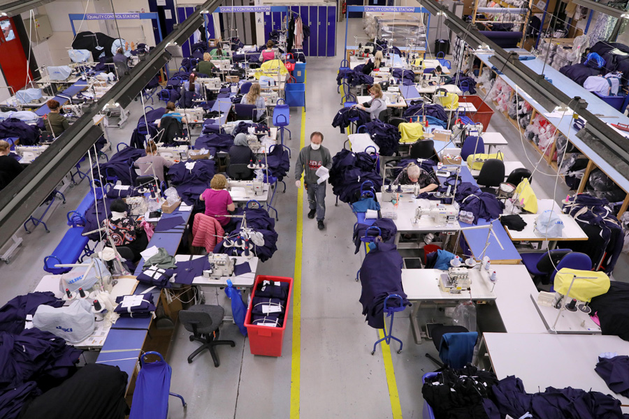 4月17日,在英国伦敦北部一家工厂,工人们在车间里制作防护服.