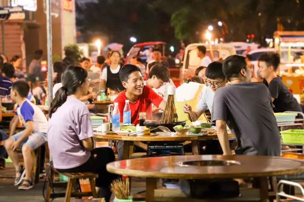 乐山夜市，人们聚在一起吃火锅。