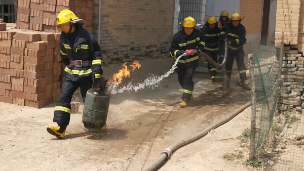消防员从失火民房中徒手拎出喷火煤气罐